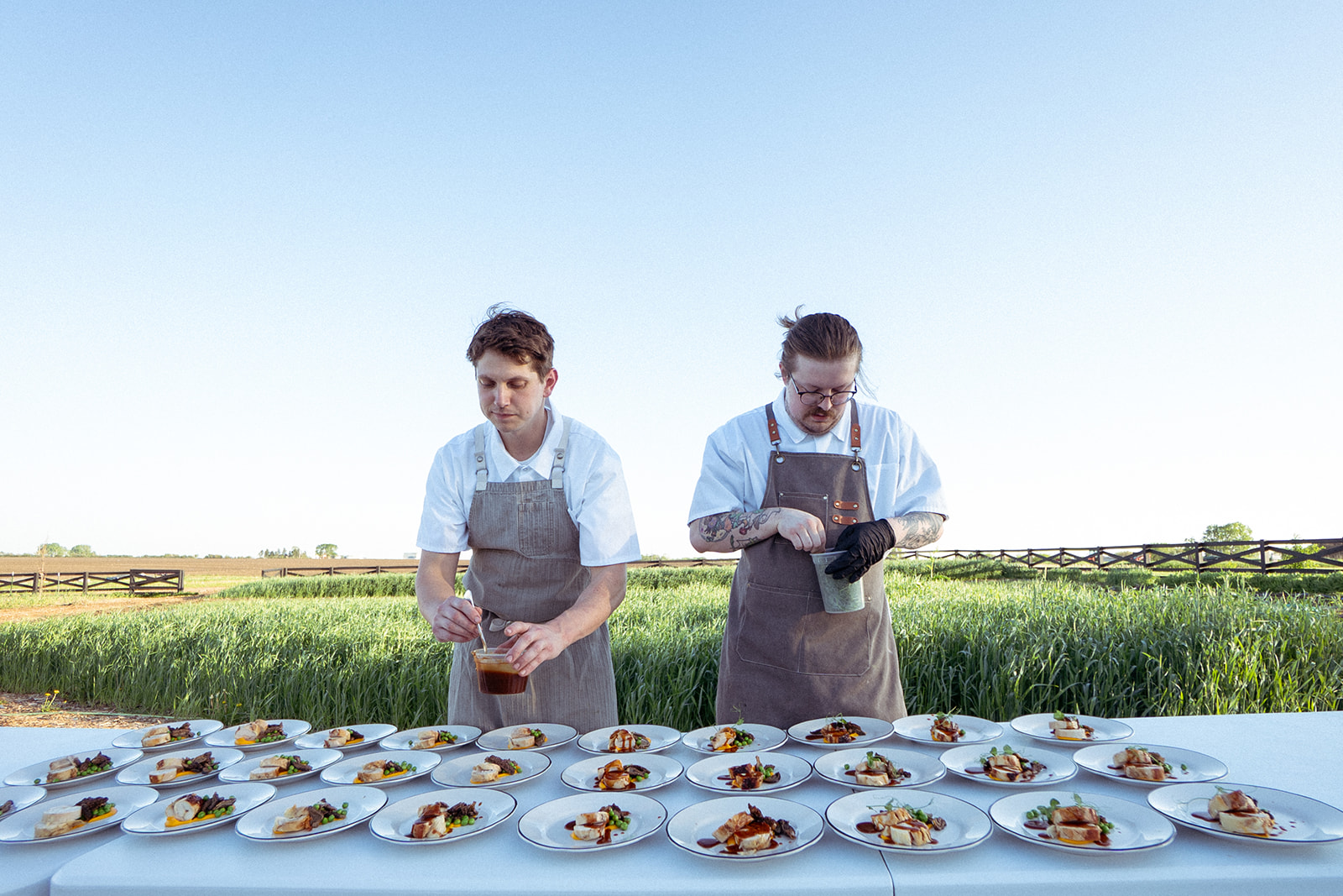 Chefs plating a farm-to-table dinner in the fields at Middlebrook